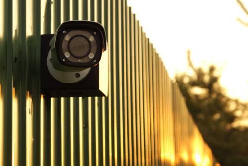 BOXFORCAM™ 4K — камера на коробке на зелёном металлическом заборе